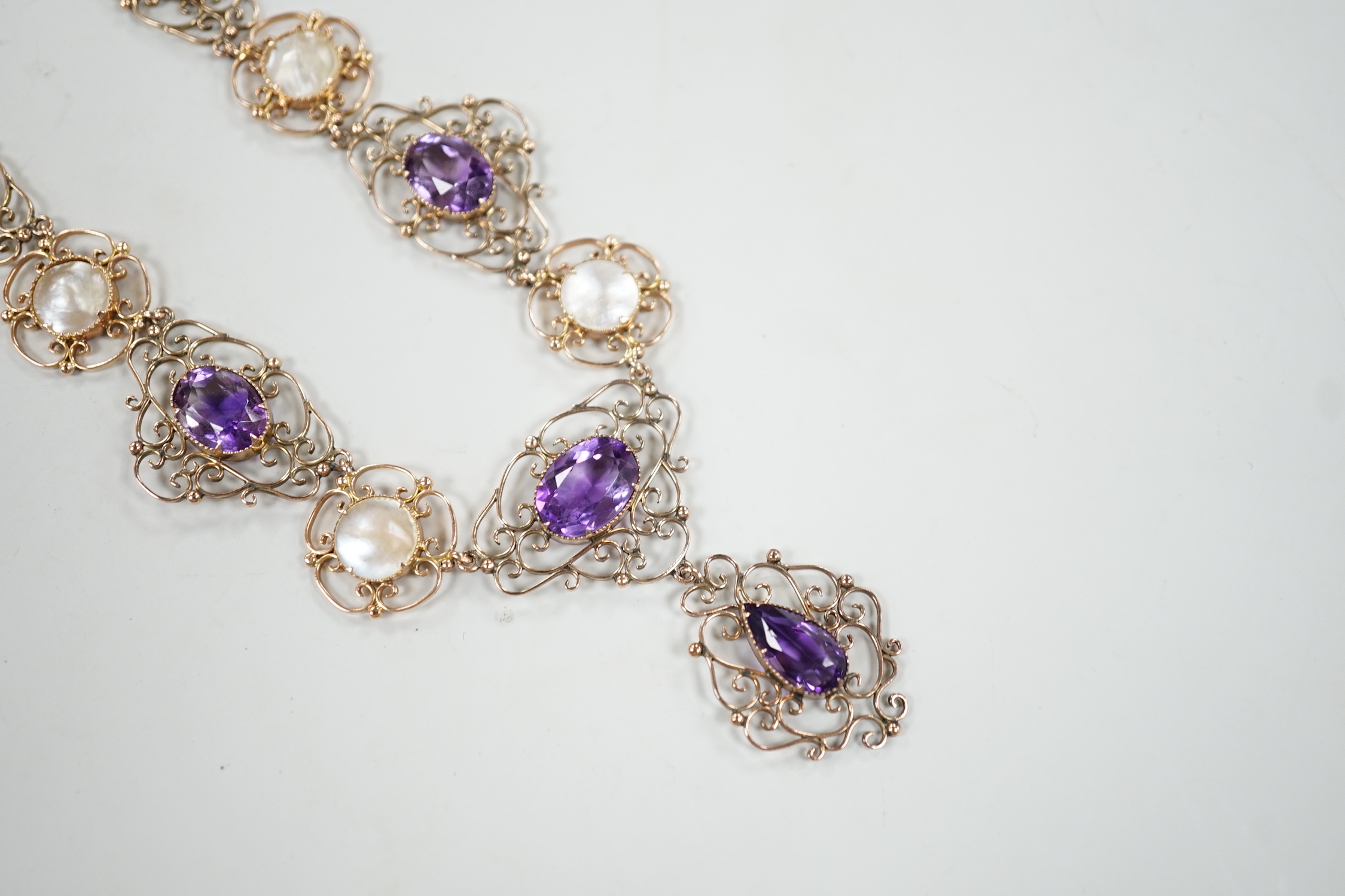 An Edwardian yellow metal, amethyst and mother-of-pearl set drop necklace, 44cm, gross weight 29.5 grams.